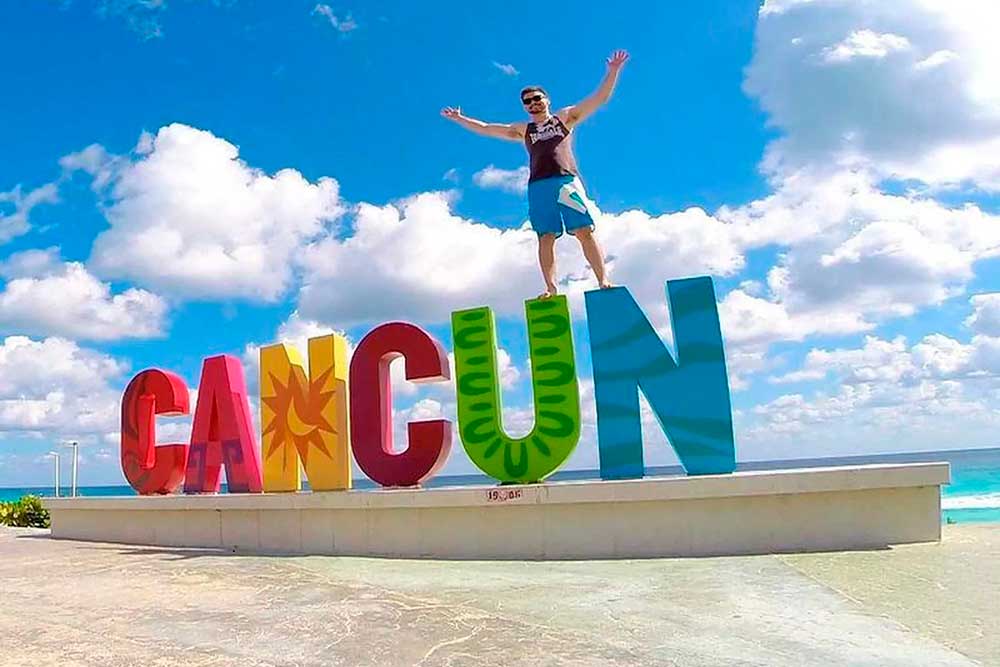 Persona arriba de las letras de cancun